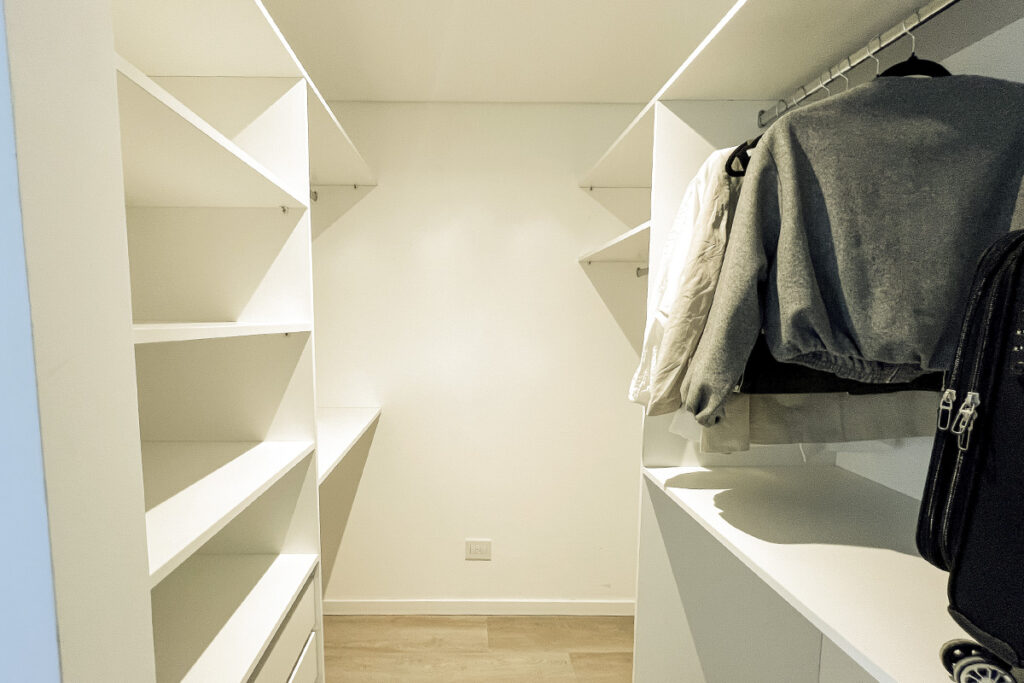 Dormitorio con aire acondicionado split y vestidor abierto visible, garantizando la climatización y espacio.